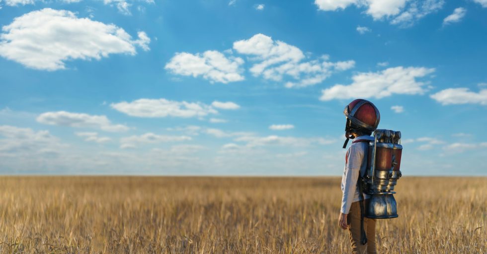 Future Little boy with a backpack and helmet outdoors